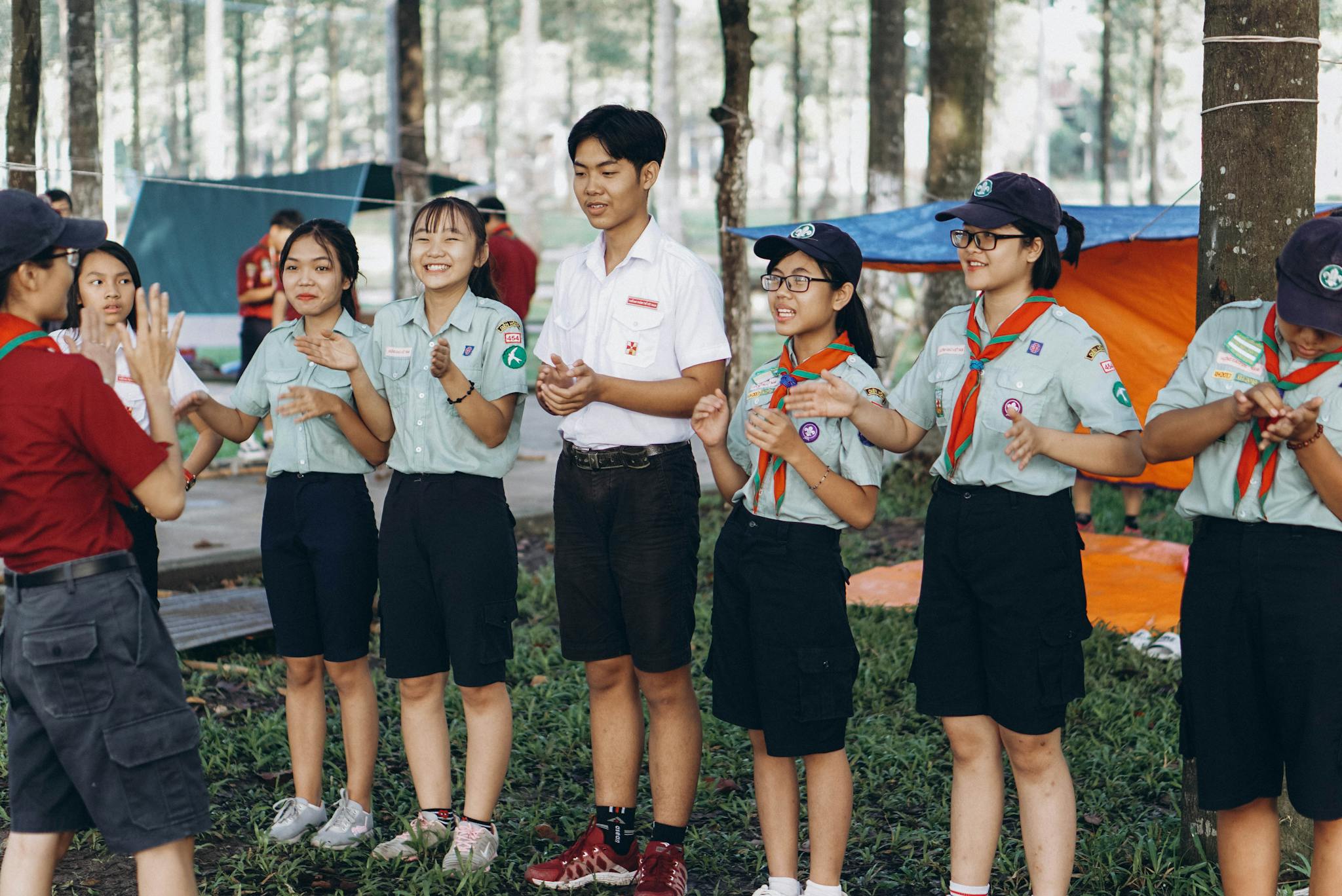 Young scouts participating in teamwork activities outdoors during a summer camp.